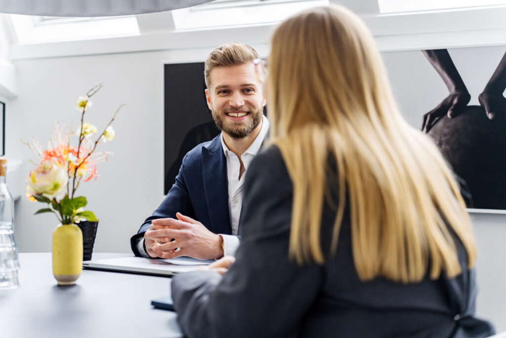 Two smiling Darize employees at a table during a meeting.