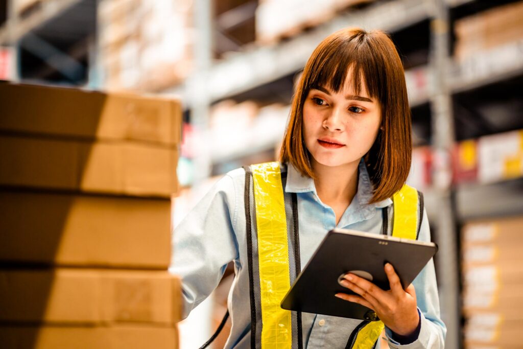 Warehouse worker checking inventory with a digital tablet
