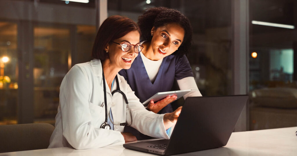 Doctor and nurse reviewing information on a laptop in a hospital