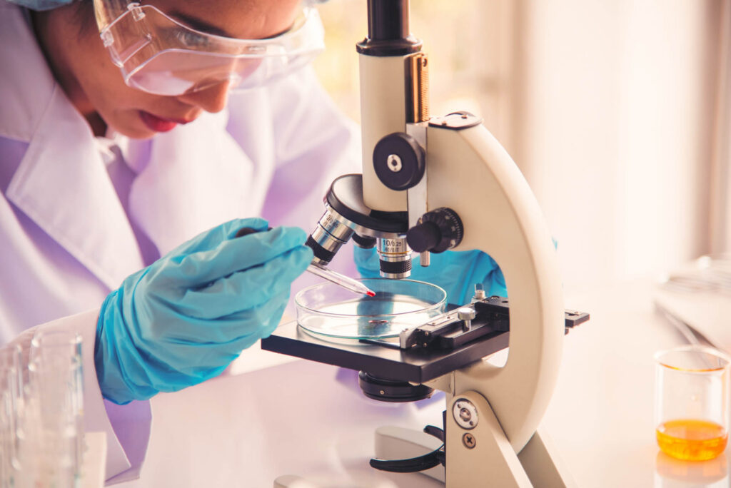Female scientist using a microscope for medical research in a laboratory