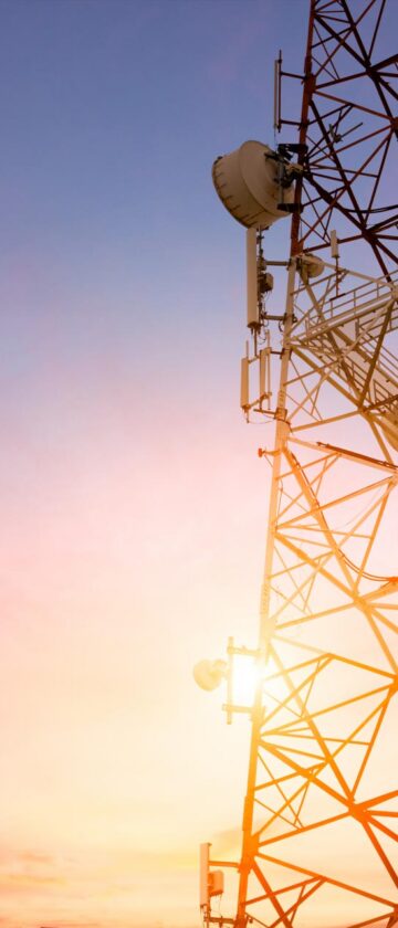 Satellite communication dish transmitting telecom network signals at sunset